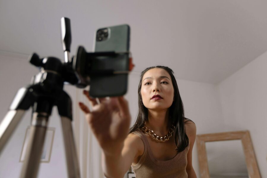 woman turning on smartphone in a tripod