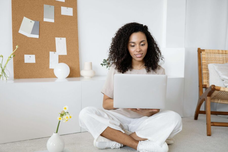 a woman sat on the floor on a laptop