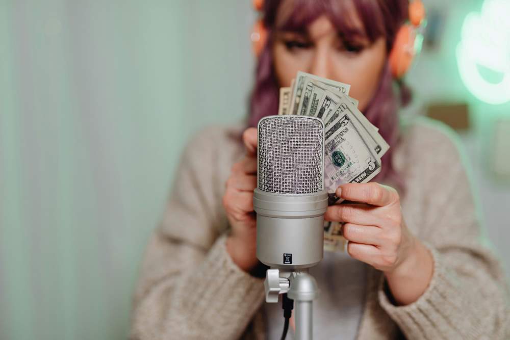 A woman holding money in front of a microphone