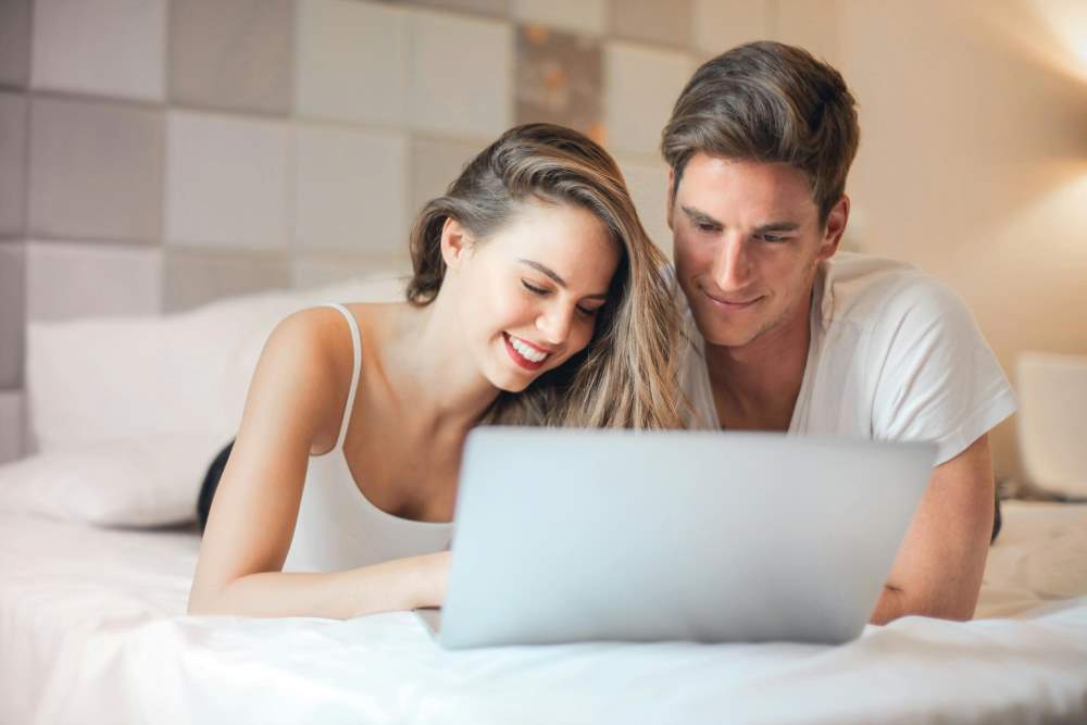 A couple on the bed on a laptop