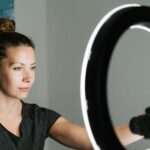a woman sat in front of a ring light about to stream