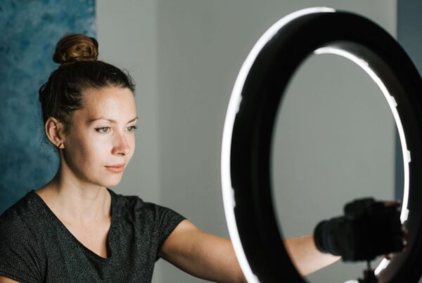 a woman sat in front of a ring light about to stream