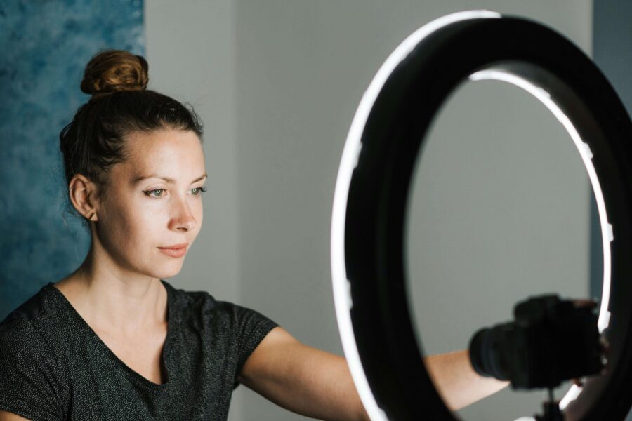 a woman sat in front of a ring light about to stream