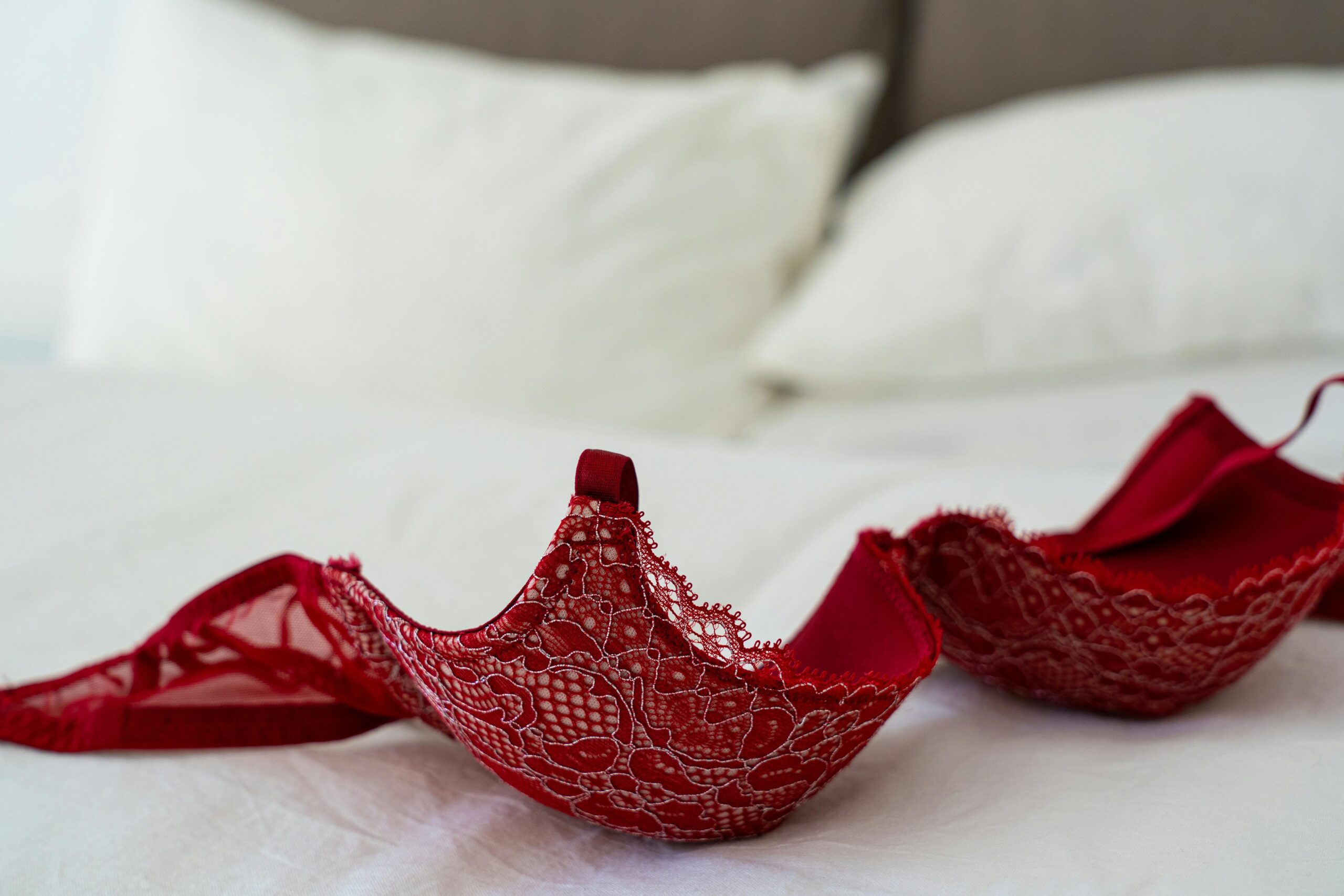 a lacy red bra lying on a bed