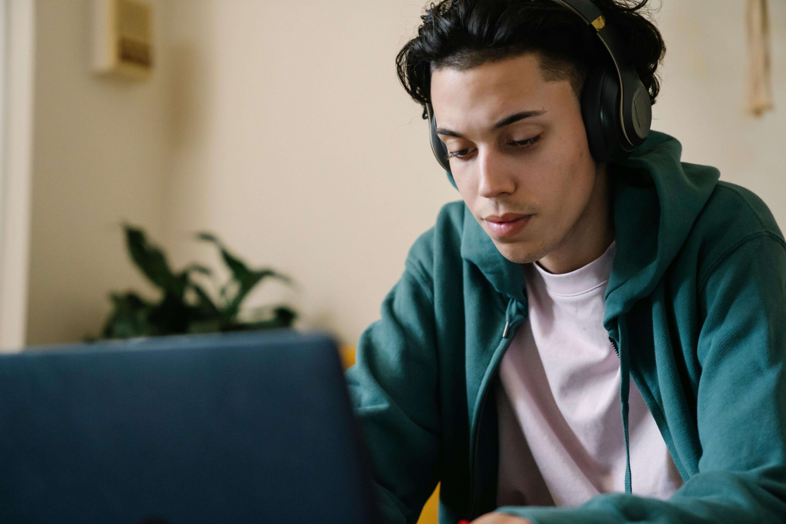 a man watching a cam girl with headphones and a laptop