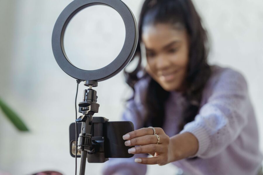 a woman setting up a smartphone and ring light to film
