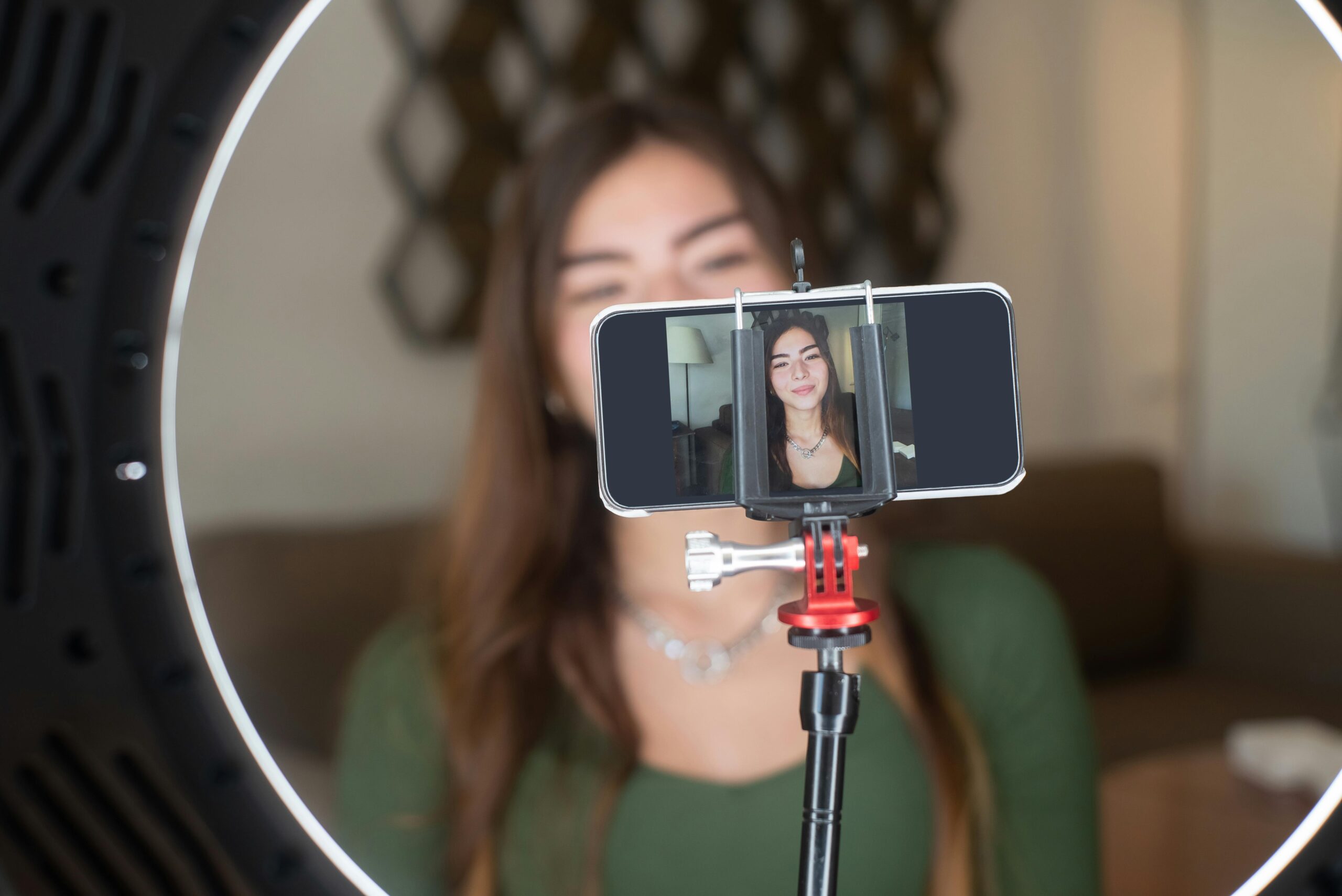 a woman filming on a smartphone using a ring light
