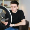 a male cam model in front of a ring light and smartphone